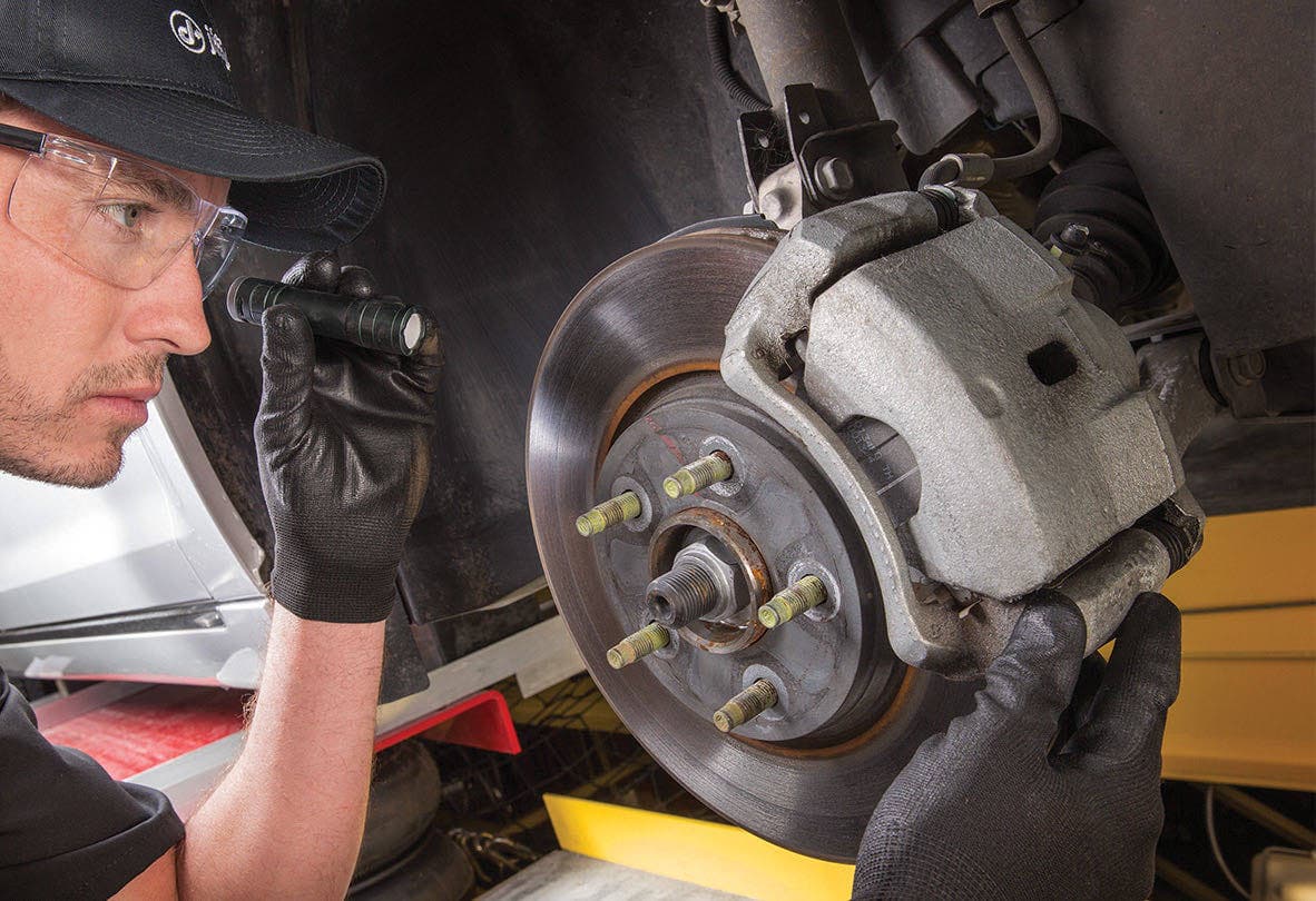 A Jiffy Lube technician inspecting brake pads and rotors in Lake City, Florida