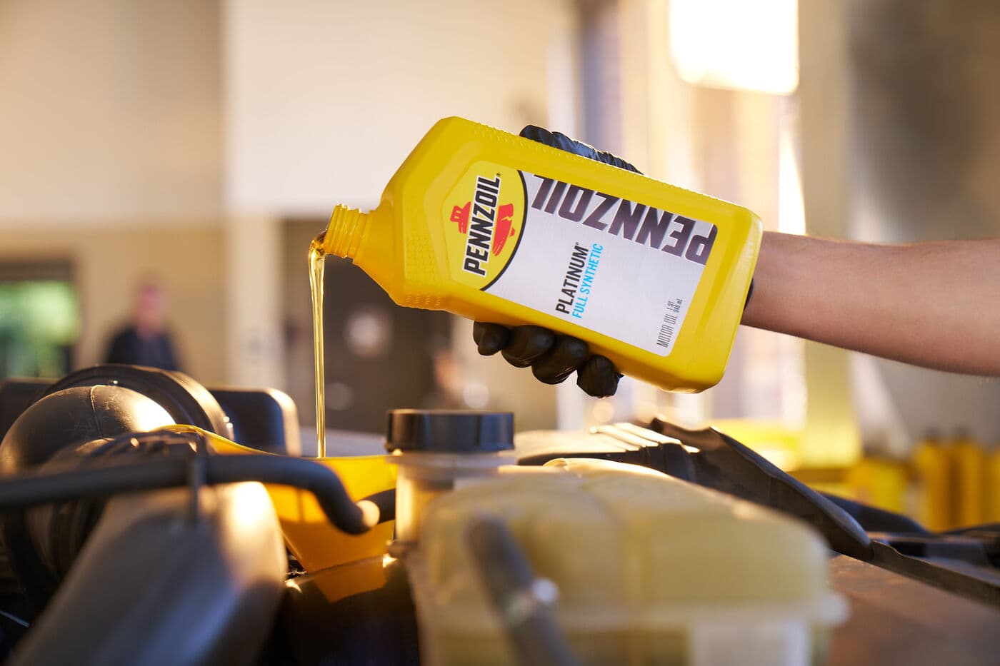 Fresh Pennzoil motor oil being added during a Suncoast Jiffy Lube oil change
