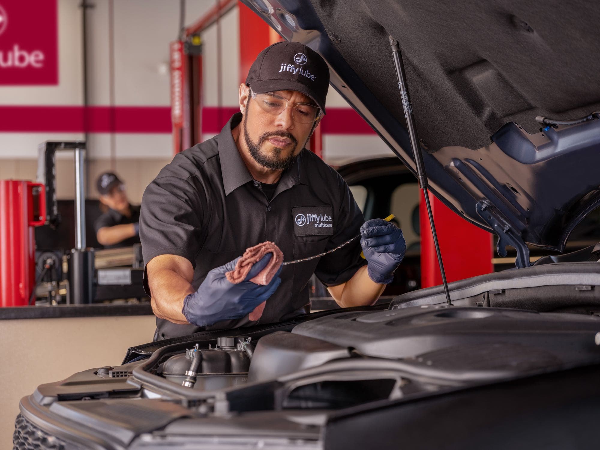 Jiffy Lube technician checking the oil level during a Signature Service oil change